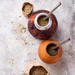 Traditional yerba mate in gourds with bombilla straws