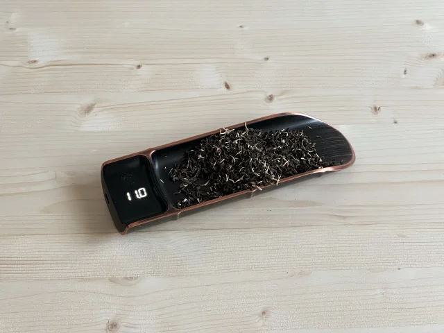 Digital scale showing NooTea leaf weighing approximately 10-12g