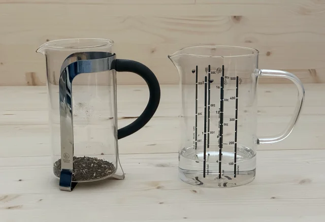 French press with tea leaves and measuring jug showing 100ml water