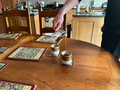 Pouring freshly brewed NooTea into handmade cups